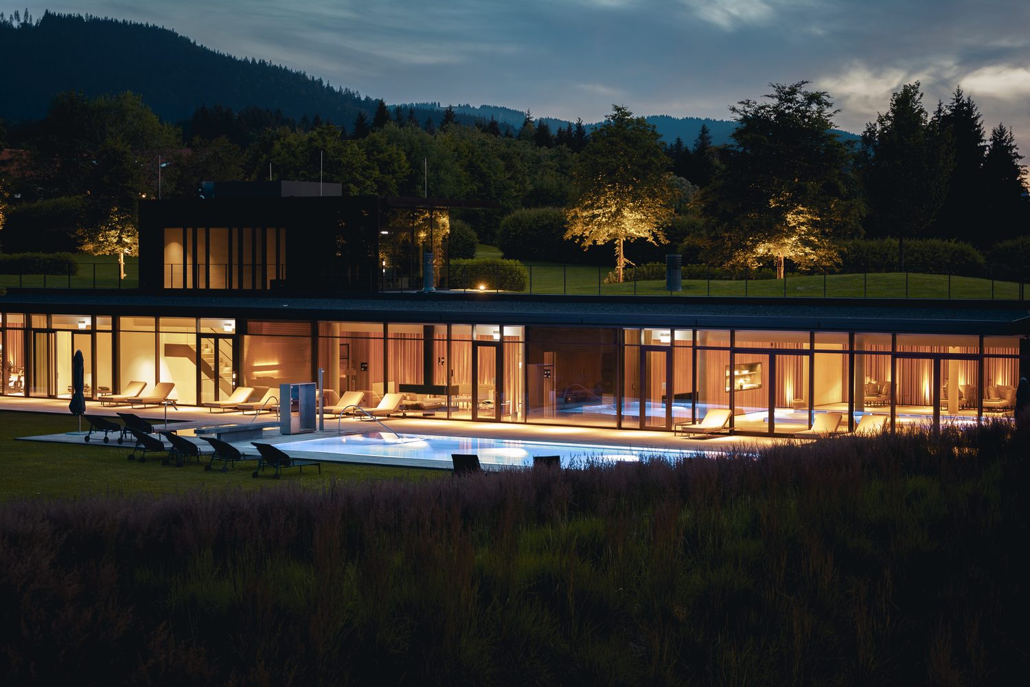 ランザーホフ テーゲルンゼーの夜の屋外プールと建物